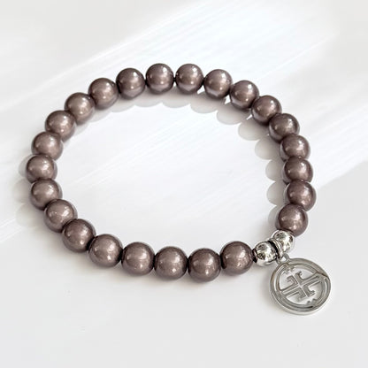 kleines perlenarmband auf weissem Hintergrund. dark taupe
