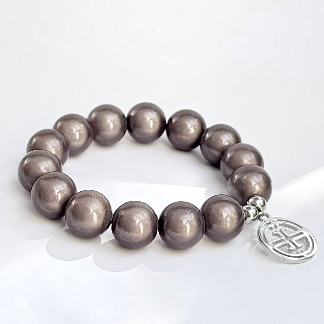 mittleres Perlenarmband auf weissem Hintergrund. dark taupe