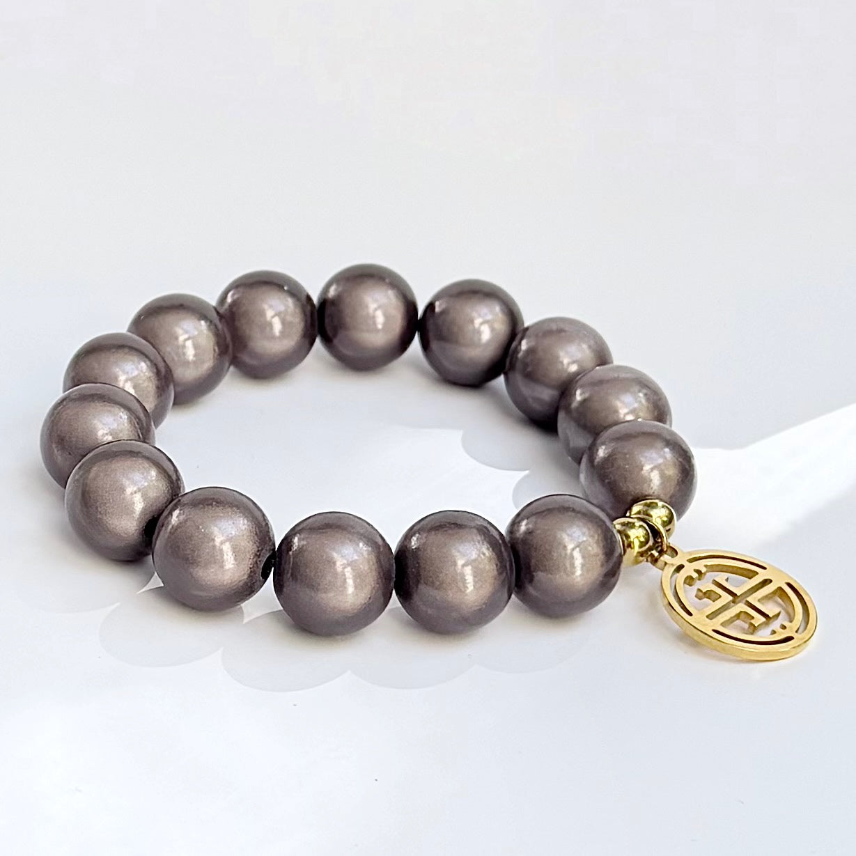 mittleres Perlenarmband auf weissem Hintergrund. dark taupe