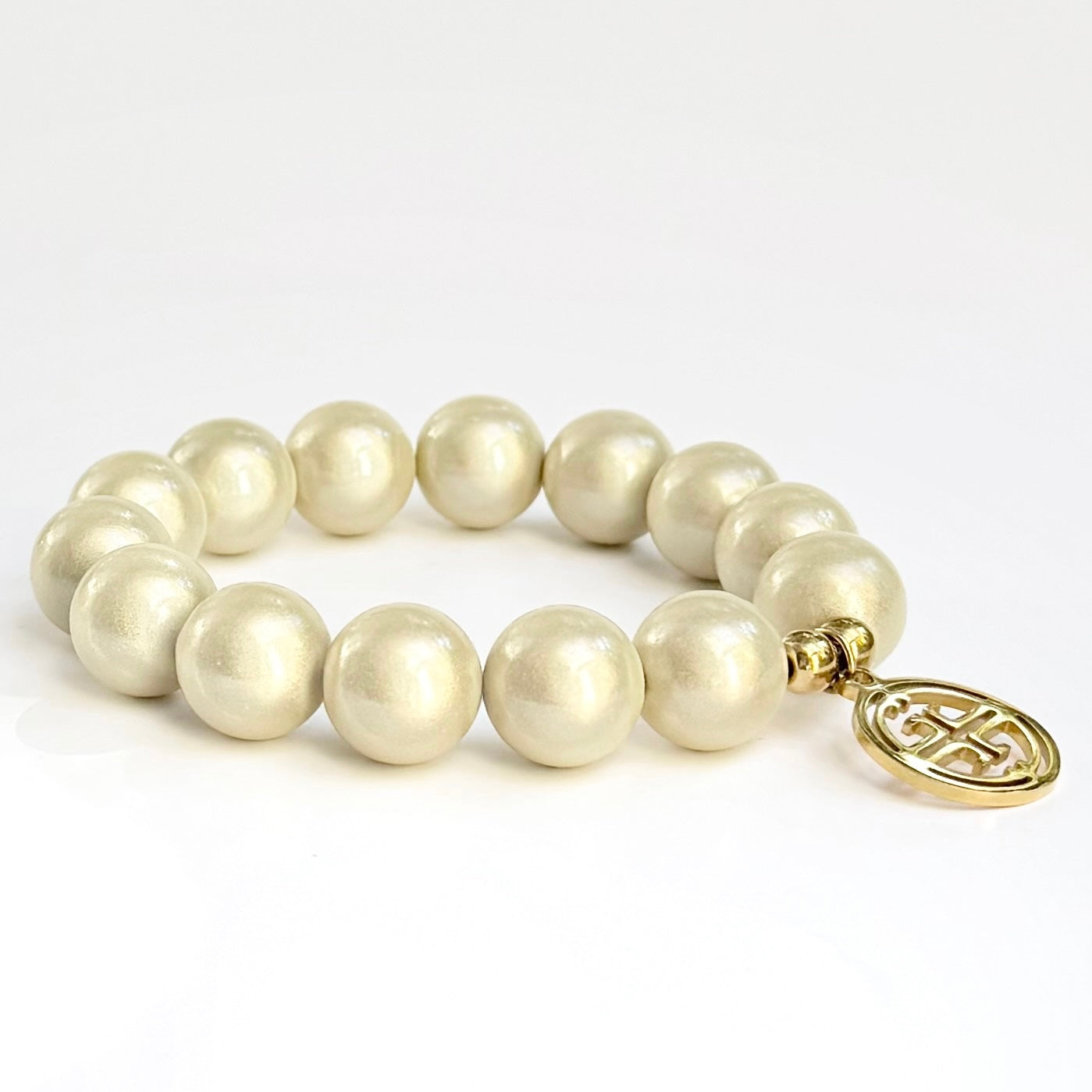 mittleres Perlenarmband auf weissem Hintergrund. champagne